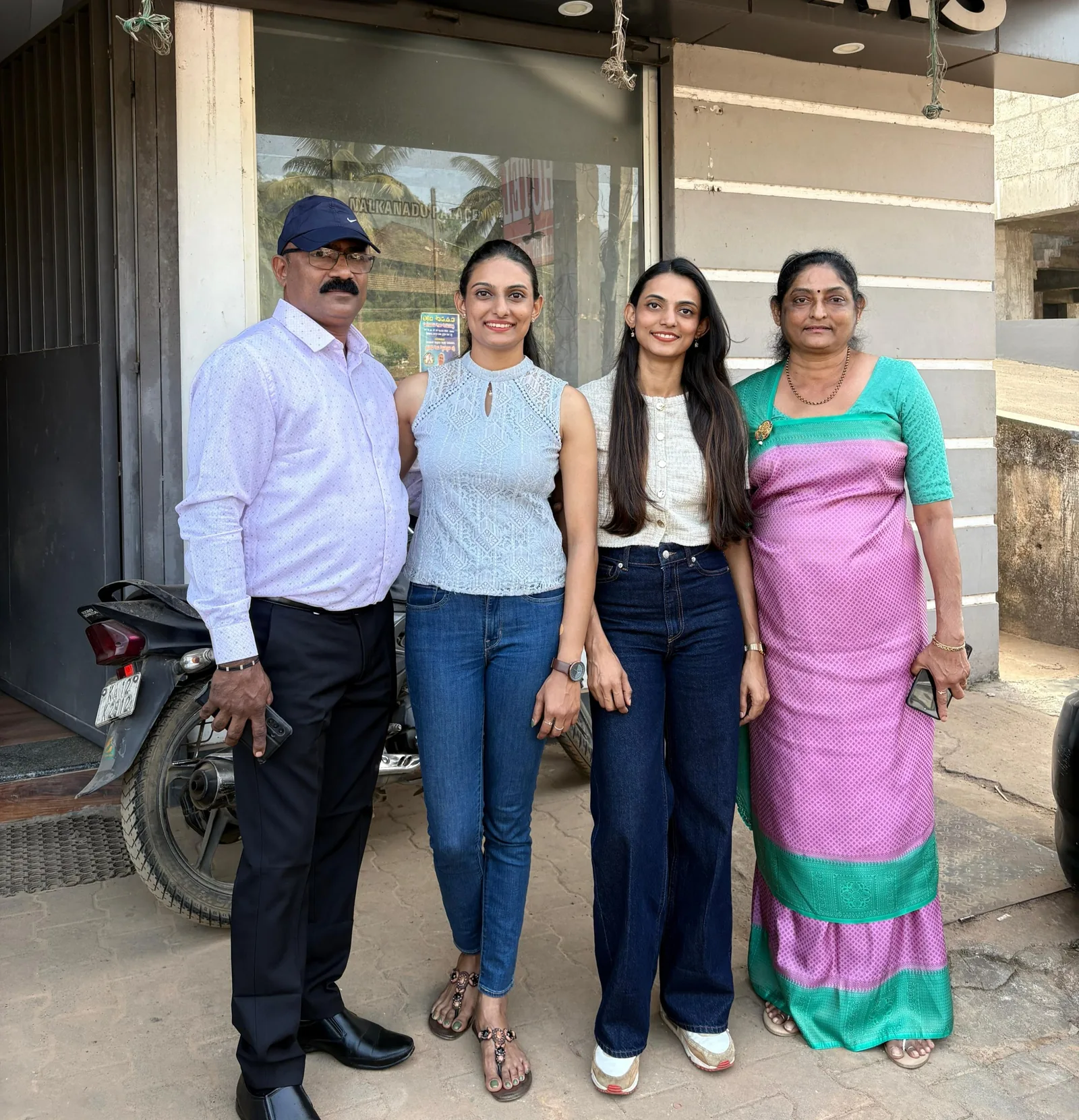 Bhavani Thekkada and her family standing together outside a shopfront in Kodagu.