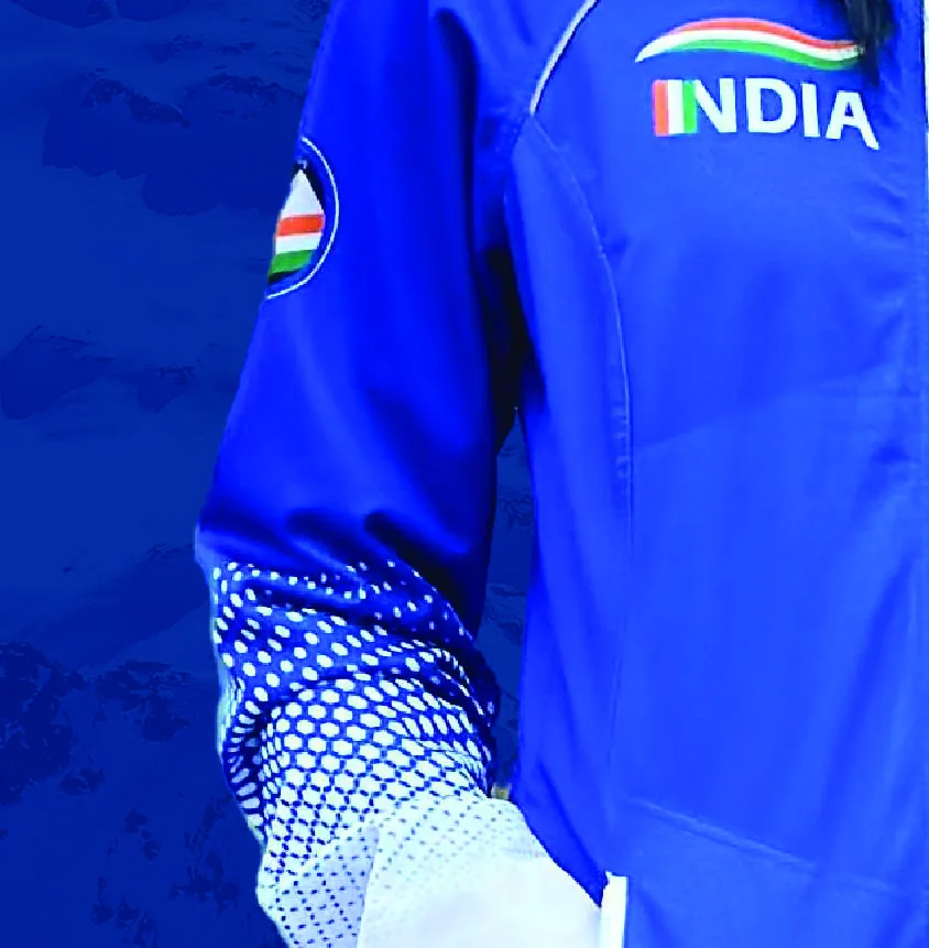 Detail of a blue team jacket sleeve carrying an INDIA wordmark and a small tricolour roundel.