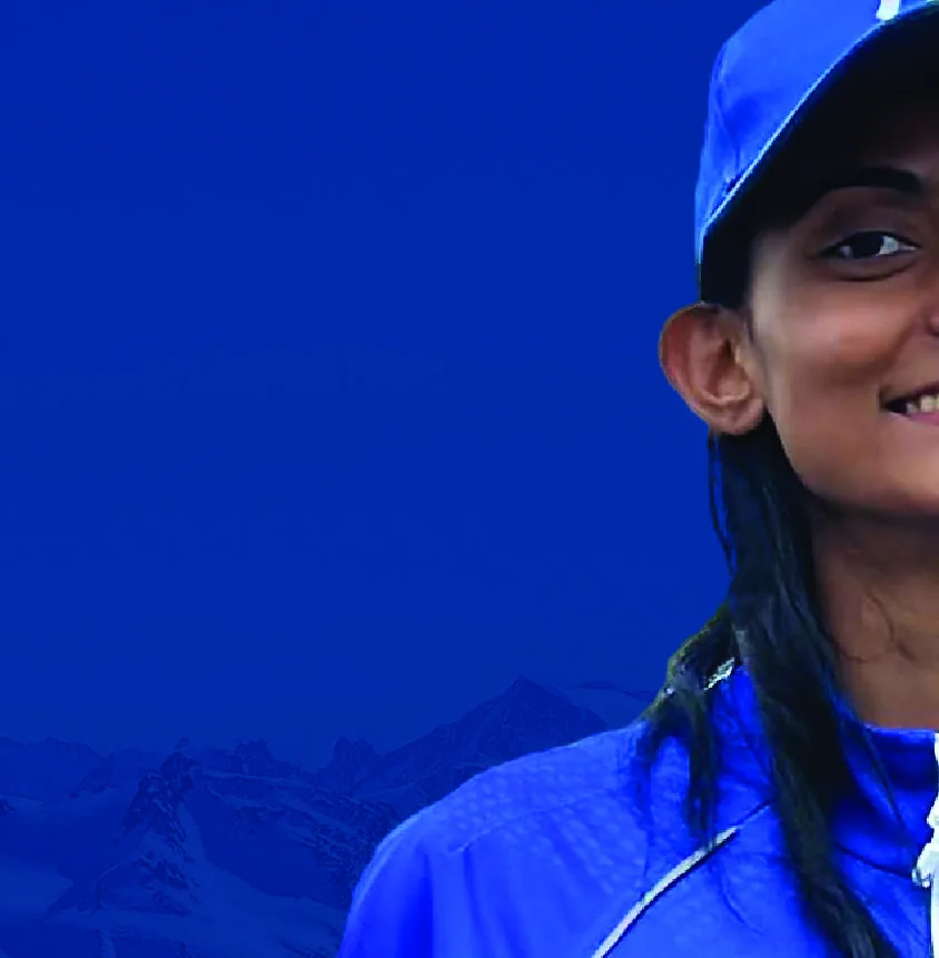 Close portrait of Bhavani in a blue team cap, half-smiling, looking past the camera.