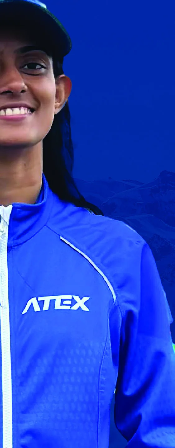 Bhavani in a blue team jacket and cap, cut out against a plain background.